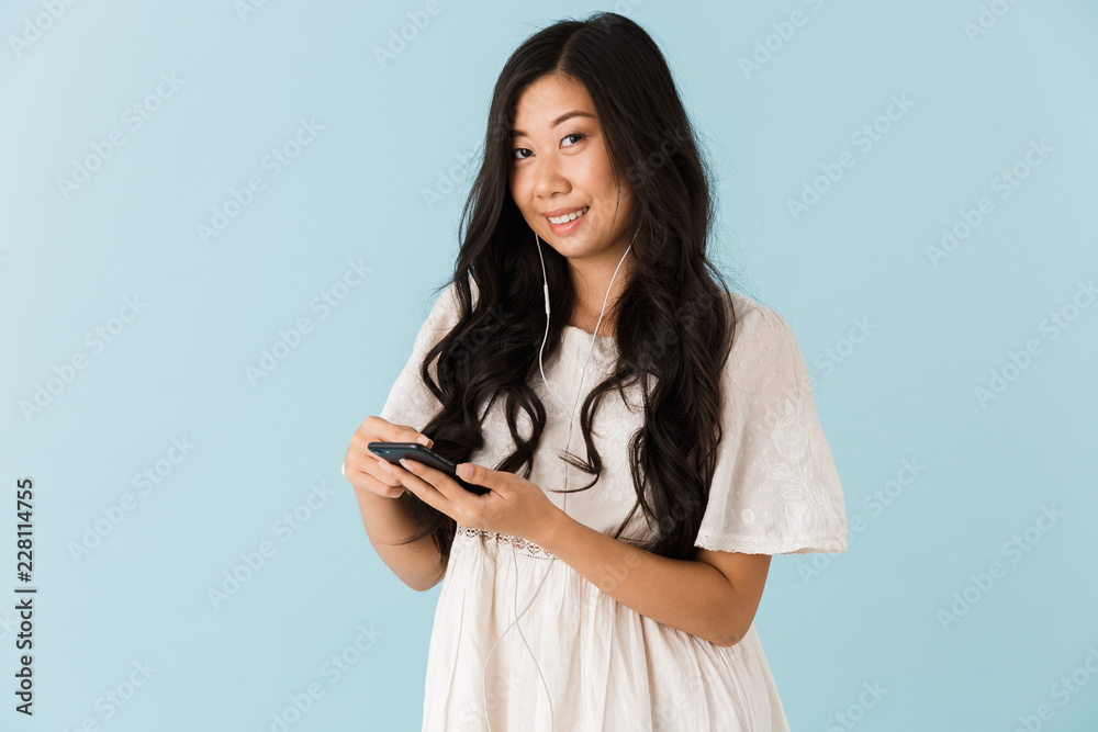 Asian beautiful woman isolated over blue background using mobile phone. Asian beautiful woman isolated over blue background using mobile phone.