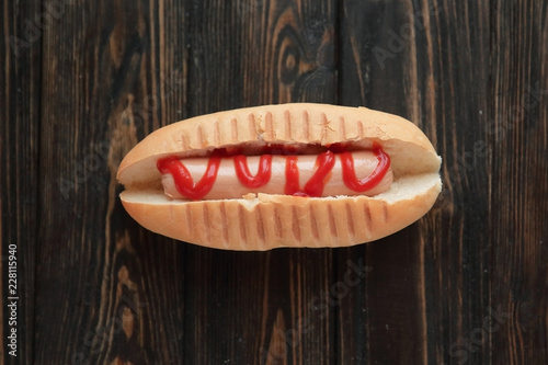 hotdog with tomato sauce on dark wooden background.photo with co