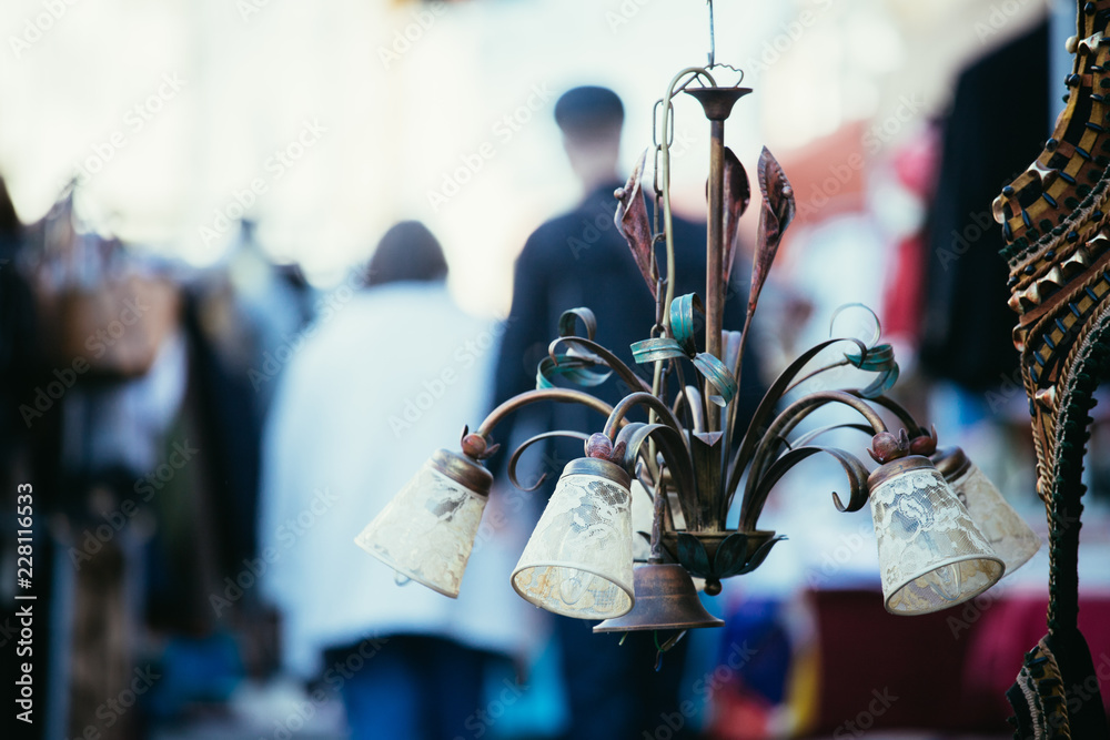 Alte Lampe/Deckenleuchte am Flohmarkt, geschäftige Menschen im Hintergrund  Stock Photo | Adobe Stock