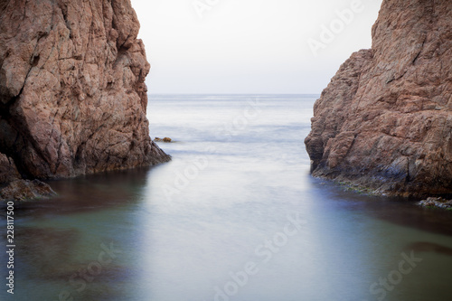 Waves hitting shore, rocks and cliffs in Tossa De Mar beach,