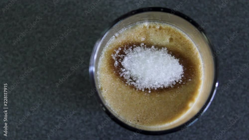 Put sugar in espresso coffee. Top view Put sugar in espresso coffee. Top view