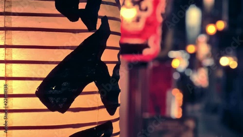 Nice evening in the small alley of the Japanese city with people walking around under the light of the restaurant's lantern.