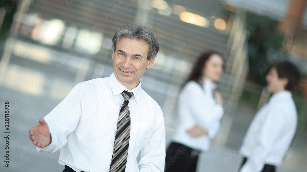 smiling businessman holding out his hand for greeting