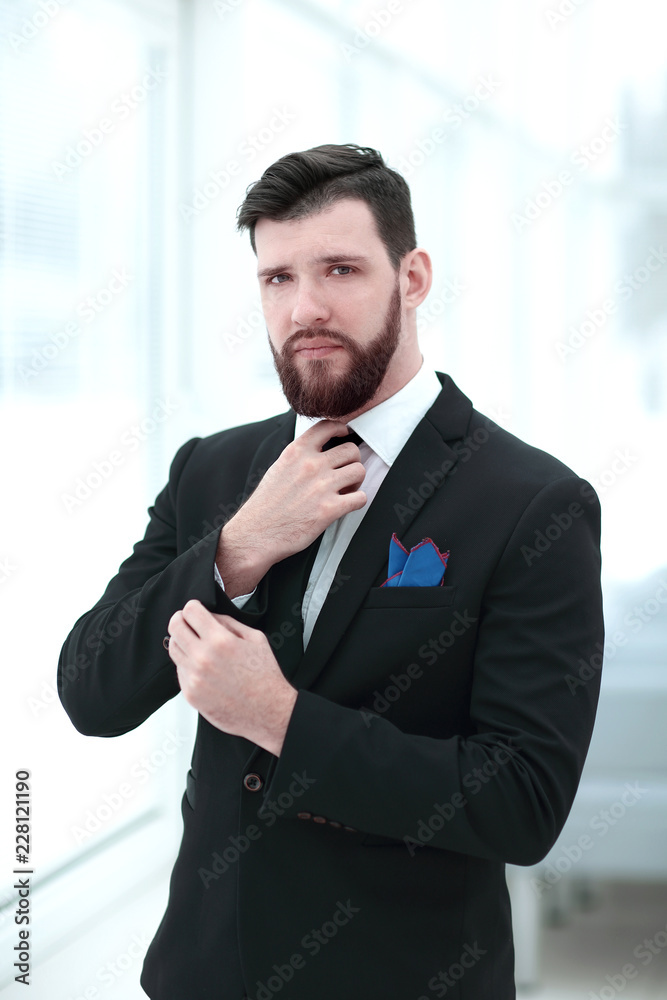 portrait of confident businessman adjusting his tie portrait of confident businessman adjusting his tie