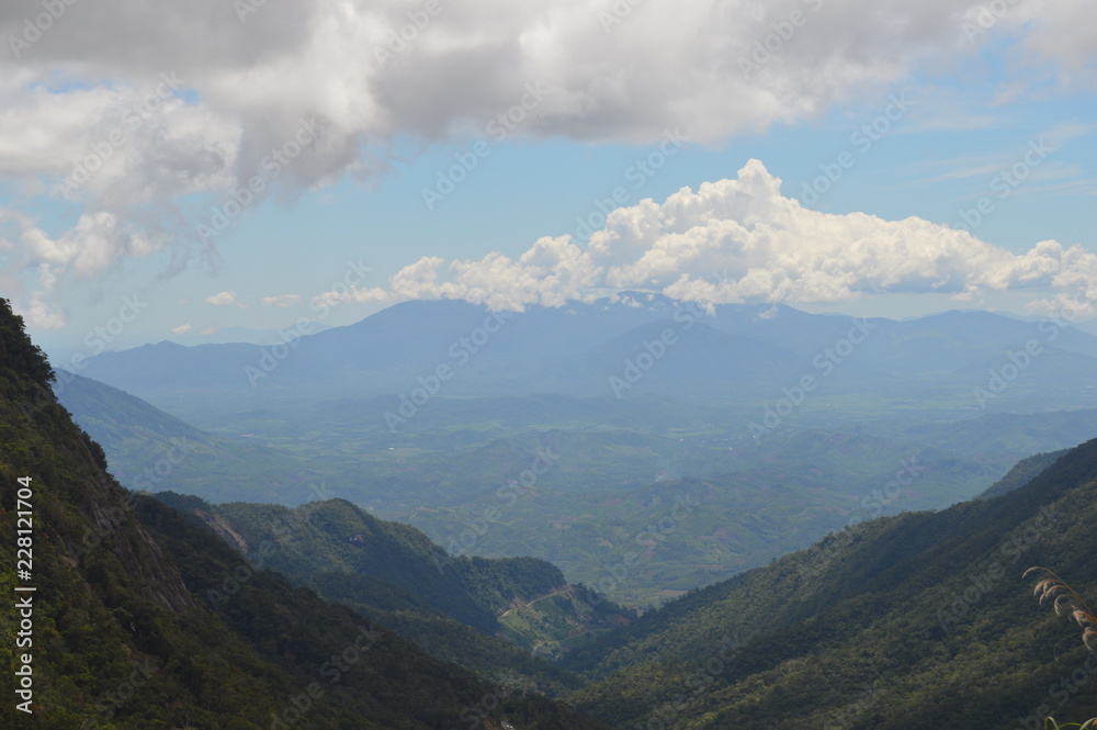 Green hill with the sky and clouds in the horizon. Trees and clouds in the background.Big white clod in the horizon. Green hill with the sky and clouds in the horizon. Trees and clouds in the background.Big white clod in the horizon.