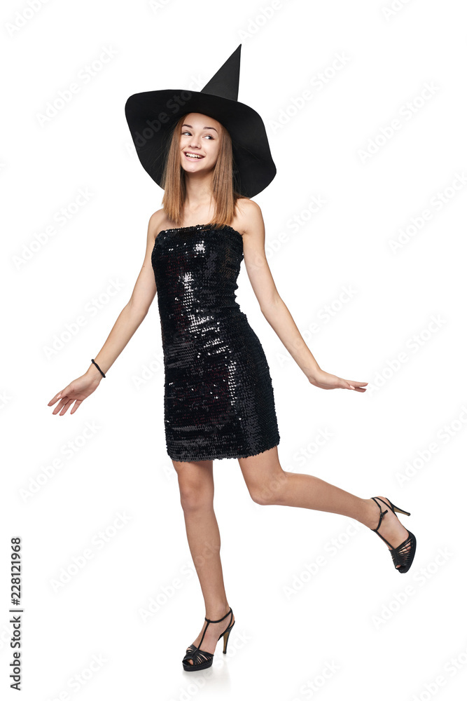 Full length playful Halloween witch isolated on white background