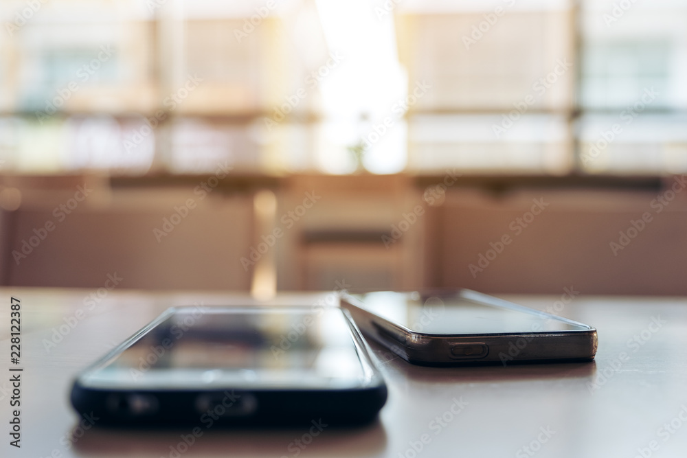 Two mobile phone on wooden table in the office Two mobile phone on wooden table in the office