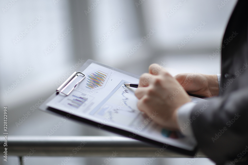 close up.businessman checking sales schedule.photo on blurred background close up.businessman checking sales schedule.photo on blurred background