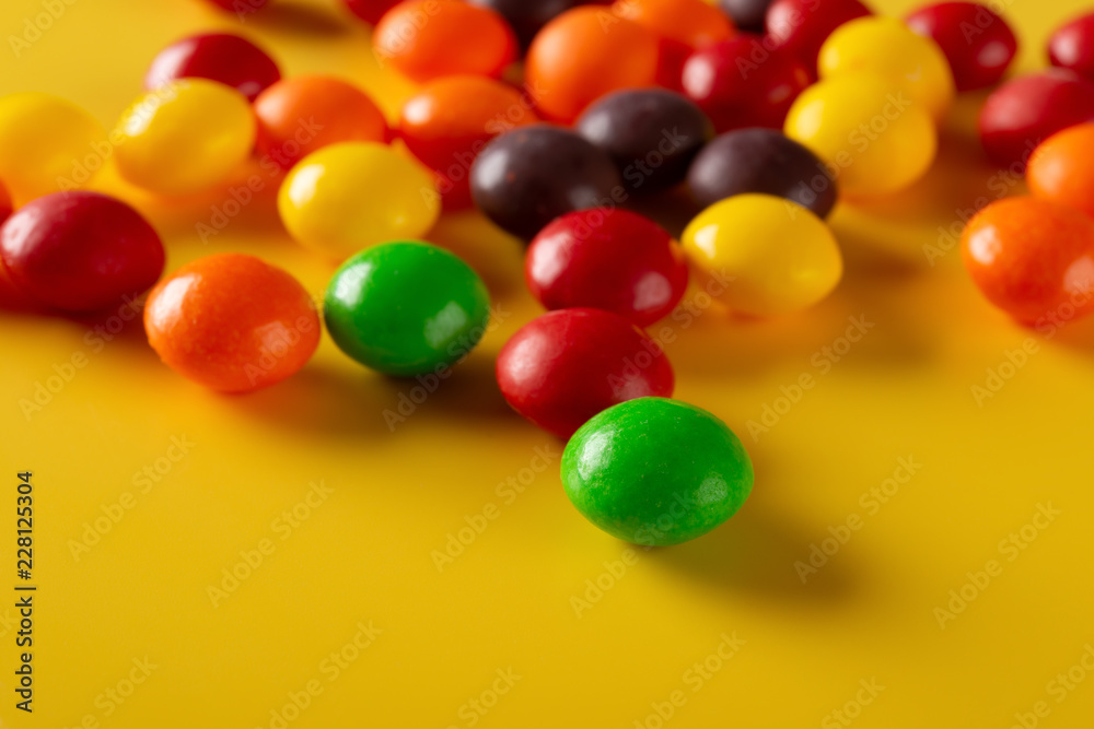 studio shot colorful chocolate buttons on yellow background studio shot colorful chocolate buttons on yellow background
