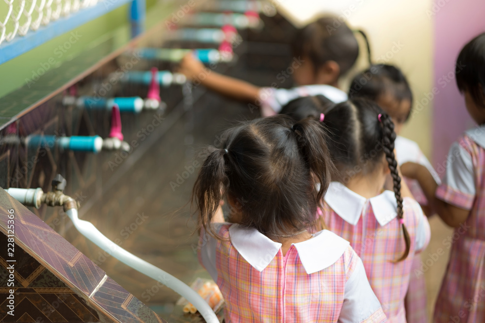 Fototapeta premium Students drinking water from the faucet after lunch.