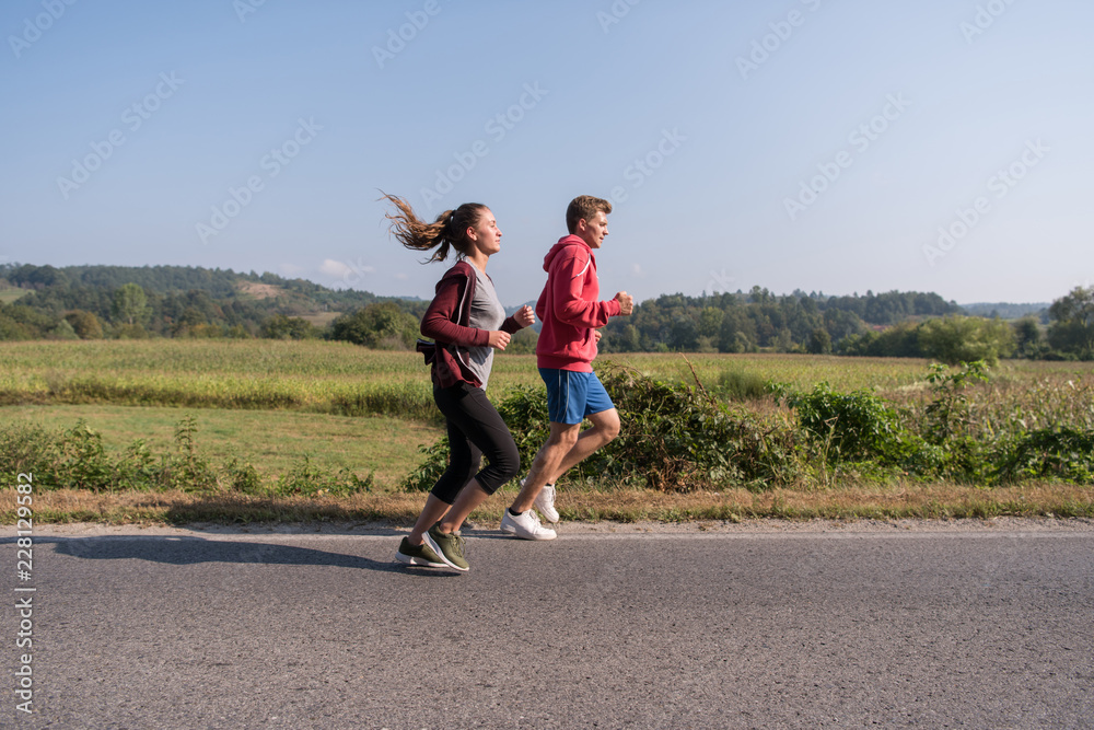 Fototapeta premium młoda para jogging wzdłuż wiejskiej drodze