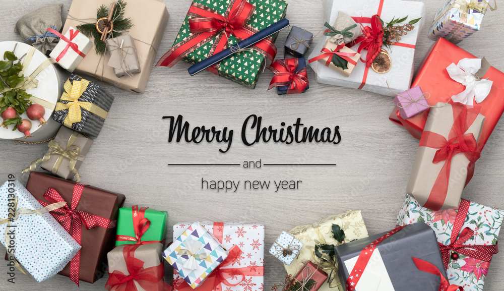 Merry Christmas and happy new year greetings in vertical top view wooden table full of christmas gifts presents.Xmas winter holiday season social media card background 