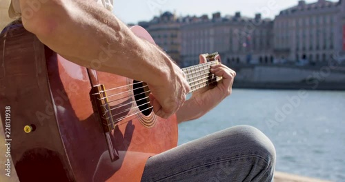 Romantic Man playing acousttic guitar near the seine river in Paris