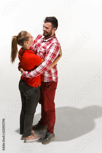 Full body portrait of hugging couple. Caucasian models in love, relationship, dating, flirting, lovers, romantic concept on white studio background. Hugging day concepts