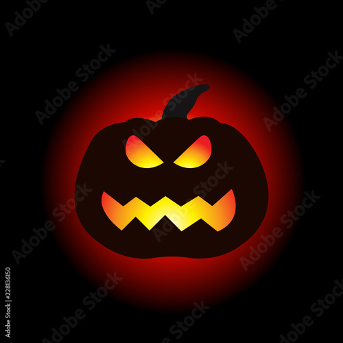 A lit Halloween pumpkin on the dark background.