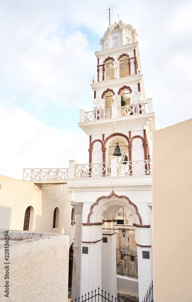 Fototapeta premium Ein schöner Kirchturm der in Santorini in den Himmel emporragt