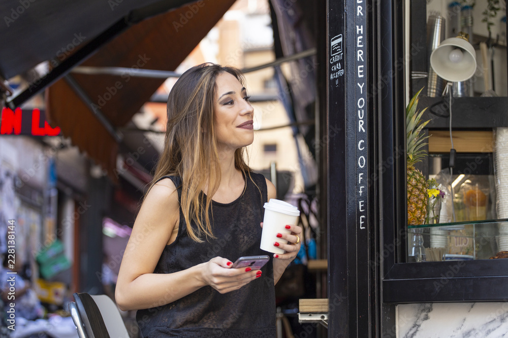 Woman with drink and smartphone near outdoor cafe Woman with drink and smartphone near outdoor cafe