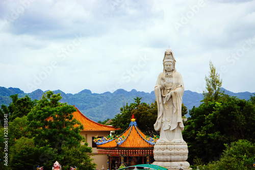 Bodhisattva Guan Yin statue along the River Kwai in front of the mountain in Kanchanaburi, Thailand. © MPIX.TURE