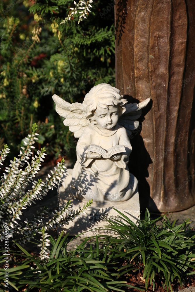 Kleiner Engel schmückt ein Grab auf dem Friedhof Kleiner Engel schmückt ein Grab auf dem Friedhof
