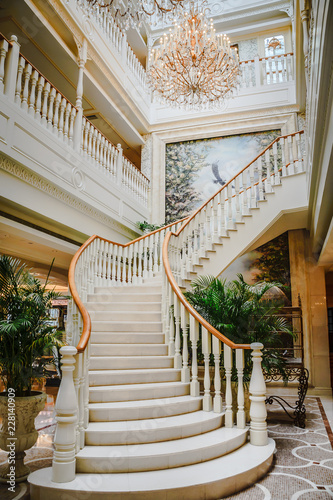 beautiful european lobby with painted wall mural, spiral staircase and chandeliers