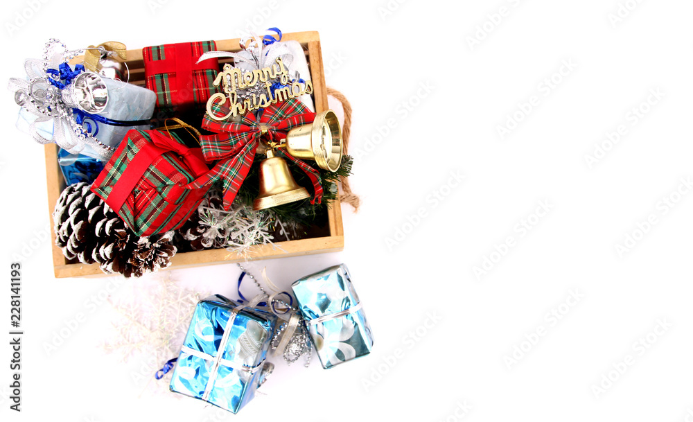 Gifts and decorations in a basket on Christmas Eve with white backdrop. Gifts and decorations in a basket on Christmas Eve with white backdrop.