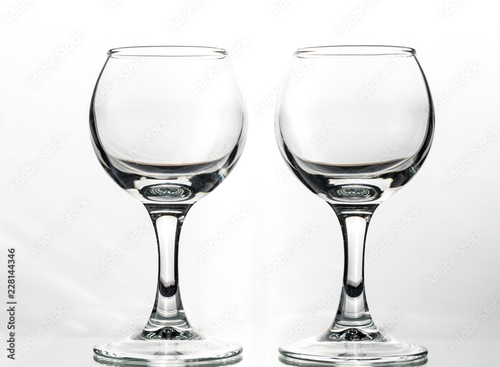 Two round glasses empty or full with waves of liquid on a white background Two round glasses empty or full with waves of liquid on a white background