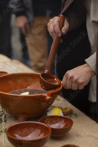 A man is preparing queimada (traditional Galician hot drink made with flamed 