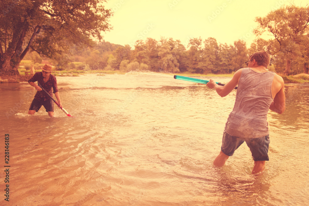Fototapeta premium young men having fun with water guns