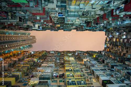 Tall skyscrapers at night towering above, crowded, moody dystopian cityscape, science fiction
