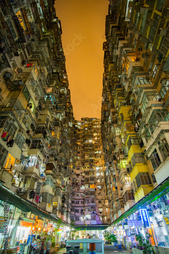 Tall skyscrapers at night towering above, crowded, moody dystopian cityscape, science fiction