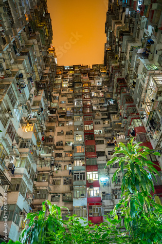 Tall skyscrapers at night towering above, crowded, moody dystopian cityscape, science fiction