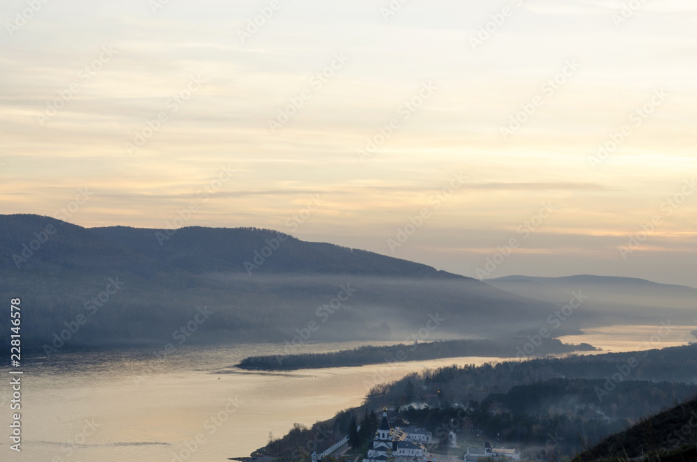 Sunset with fog over the river view from great height soft colors