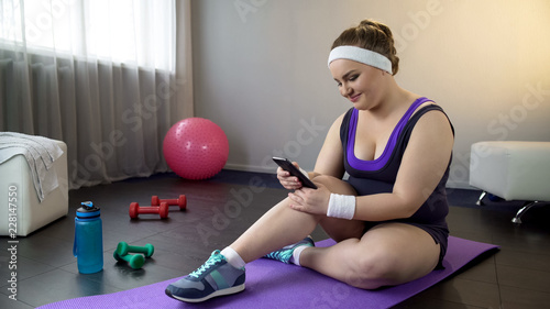 Quadro em tela Plump girl delighted to see her weight loss result in smartphone app, fitness