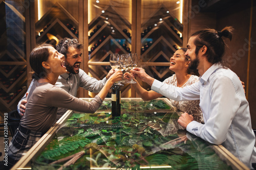 Canvas Print Happy couples toasting with wine at a restaurant