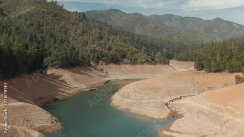 Aerial view of Shasta Lake flying by the water with hills in the background  Northern California low water levels during drought photo