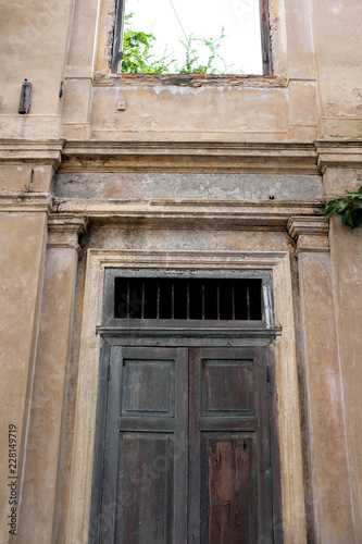 Vintage colonial wooden door frame and rustic concrete building facade