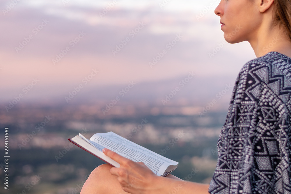 © PhotoGranary - Christian worship and praise. A young woman is reading the bible.