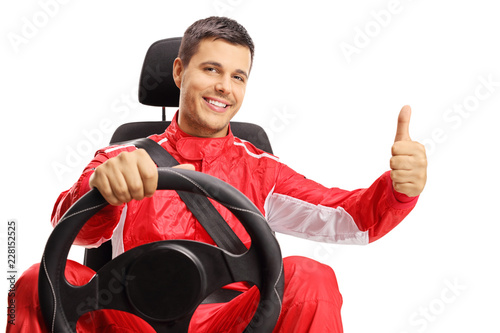 Race driver in a car seat making a thumb up sign
