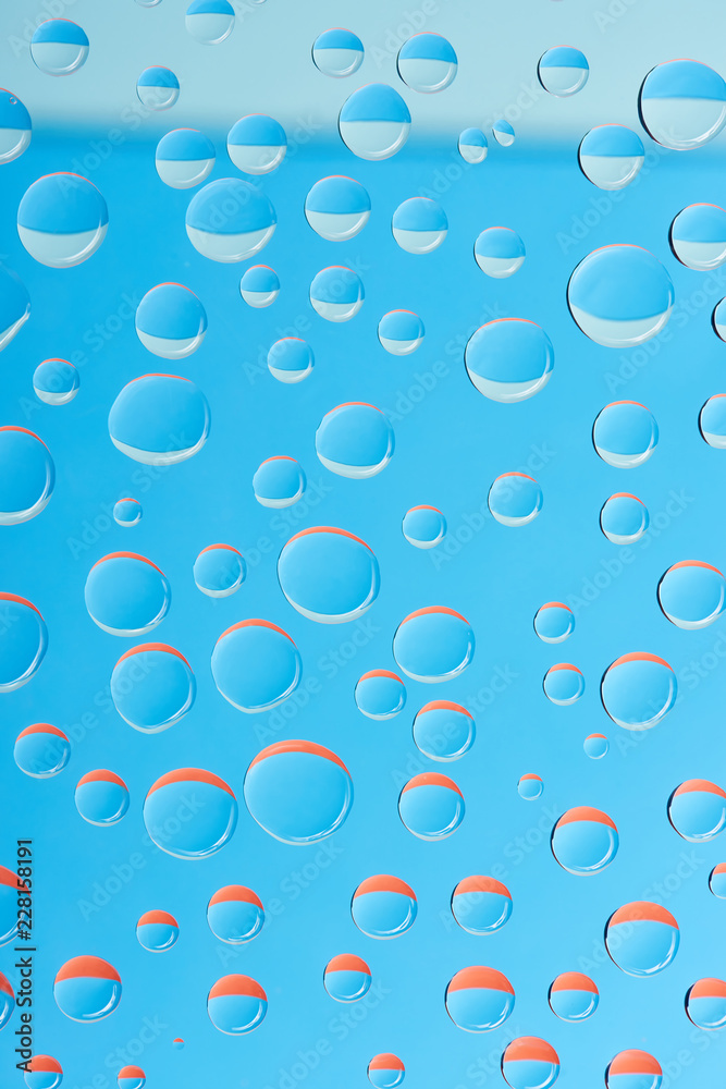 close-up view of transparent water drops on bright blue background close-up view of transparent water drops on bright blue background