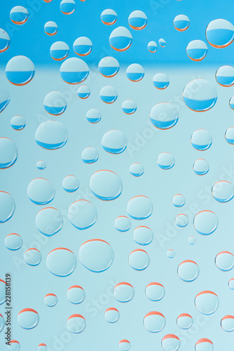 close-up view of transparent droplets on light blue background