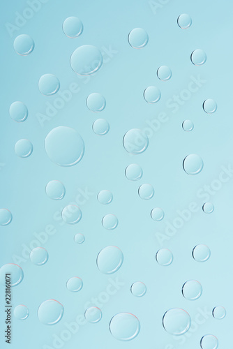 close-up view of transparent water drops on light blue background