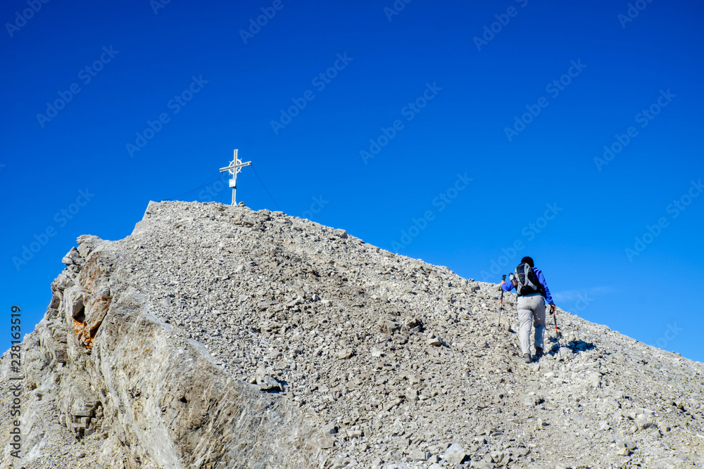 Junge Frau auf dem Weg zum Gipfelkreuz