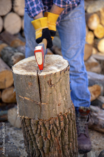 The worker is working the ax. Ax close up. An ax in a tree chopping action. A man chops off a tree with an ax with dust and movements.