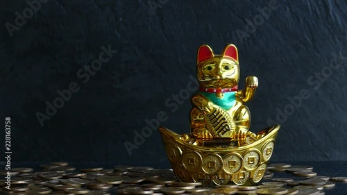 Maneki Neko Japanese lucky cat waving paw and drops a lot of coins for money luck.Slow motion video