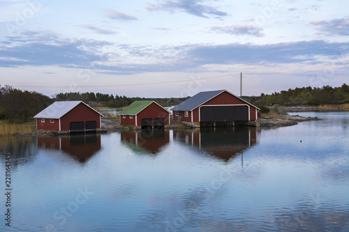 Foto Evening coastal view, traditional wooden boathouses, Kumlinge, Aland islands, Fi