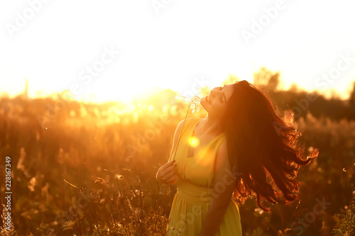 Fashion Lifestyle, Portrait of Beautiful Young Woman with long dark hair Backlit at Sunset Outdoors. Soft warm sunny colors