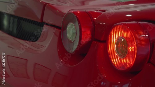 Turning signals of red sport car blink. Close up view