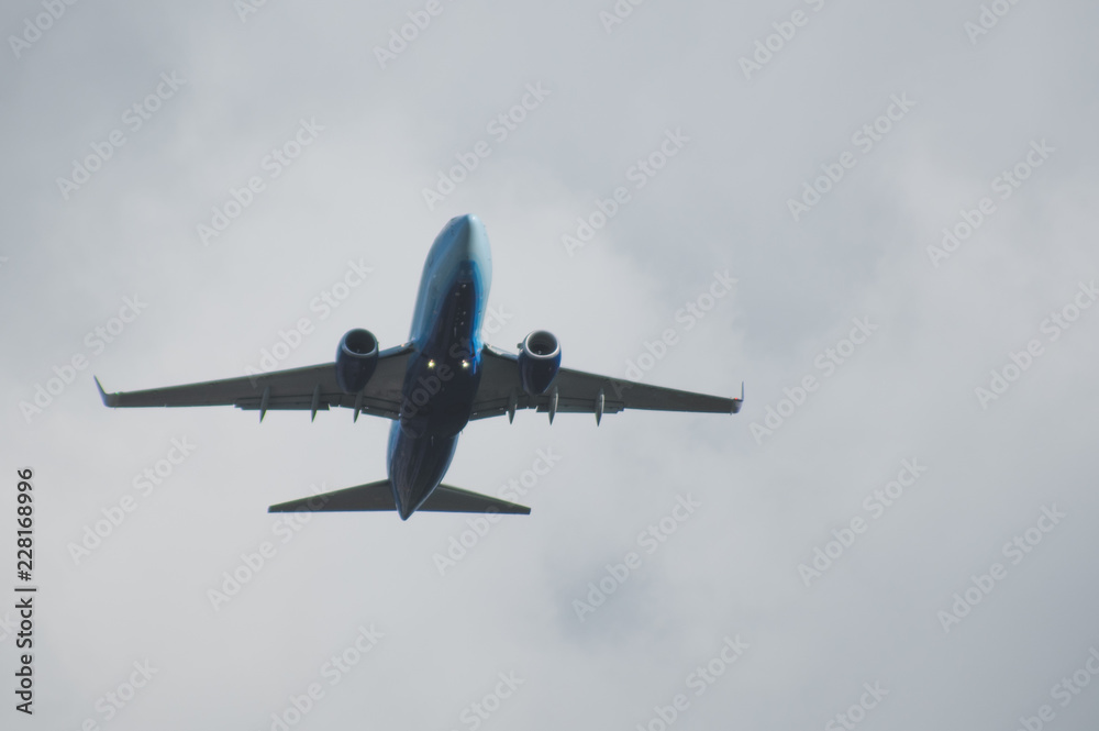 Fototapeta premium Silhouette of a plane taking off against the blue sky