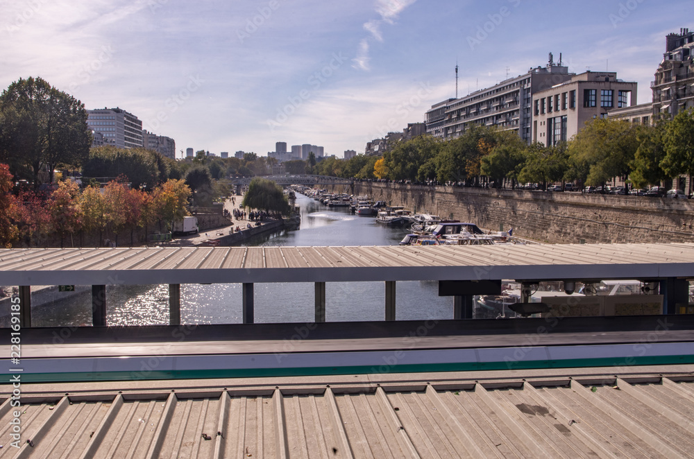 Fototapeta premium Boats parked in a port in front of buildings in Paris on the banks of the Seine in autumn