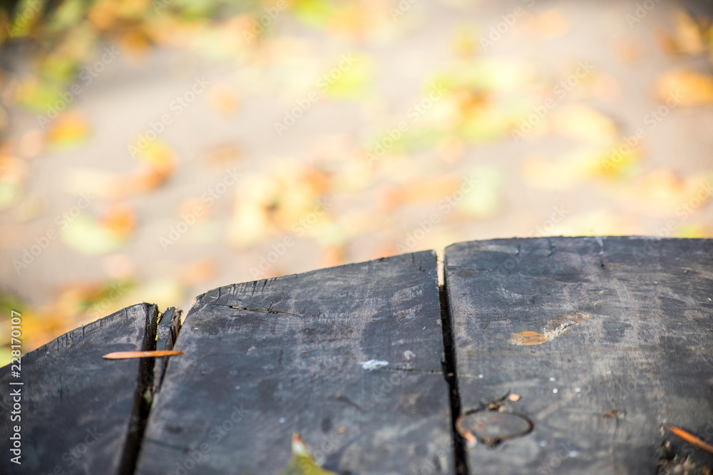 Fototapeta premium Bright autumn blurred background and edge of a wooden table